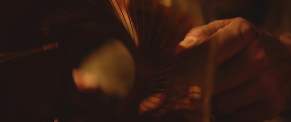 Person holds tubular copper metal object with straight flared edges and etched parallel lines