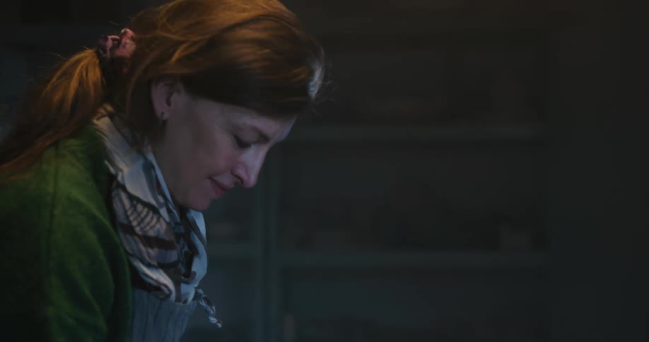 A woman is wiping a piece of clay on the table