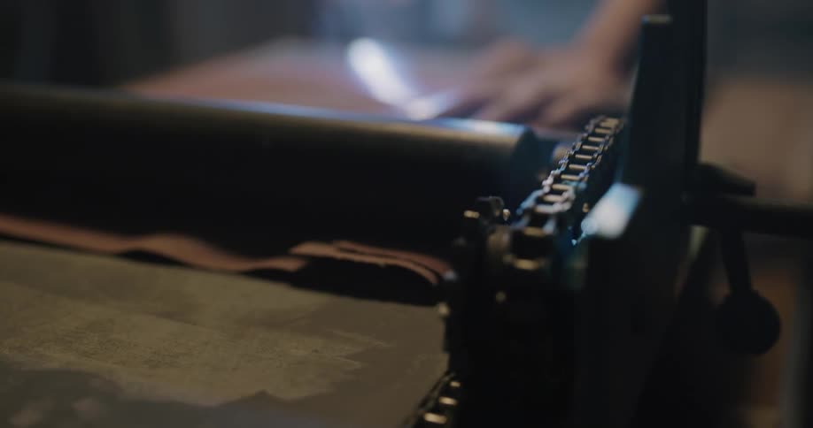 A person working on leather with a machine