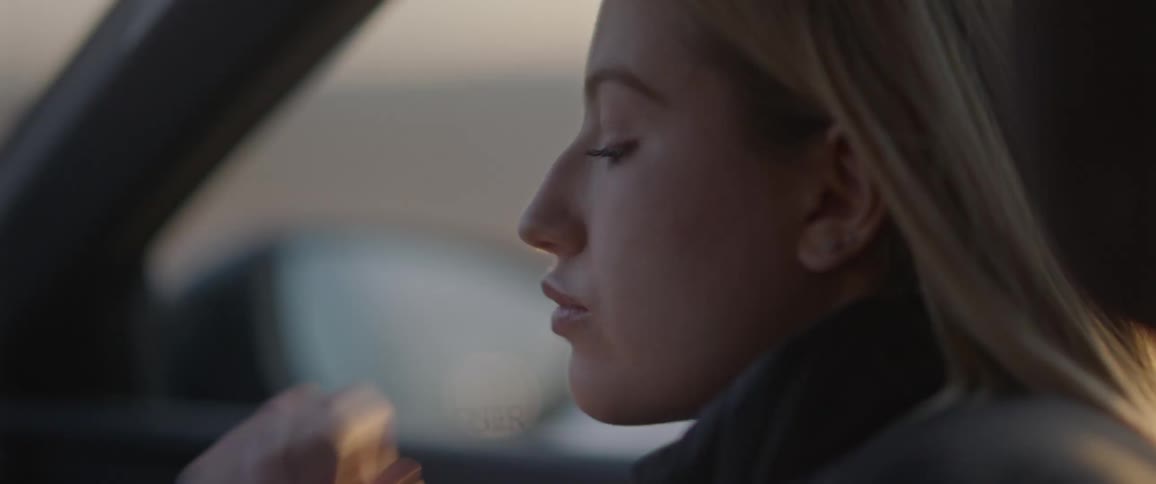 A woman sits in the passenger seat of a car