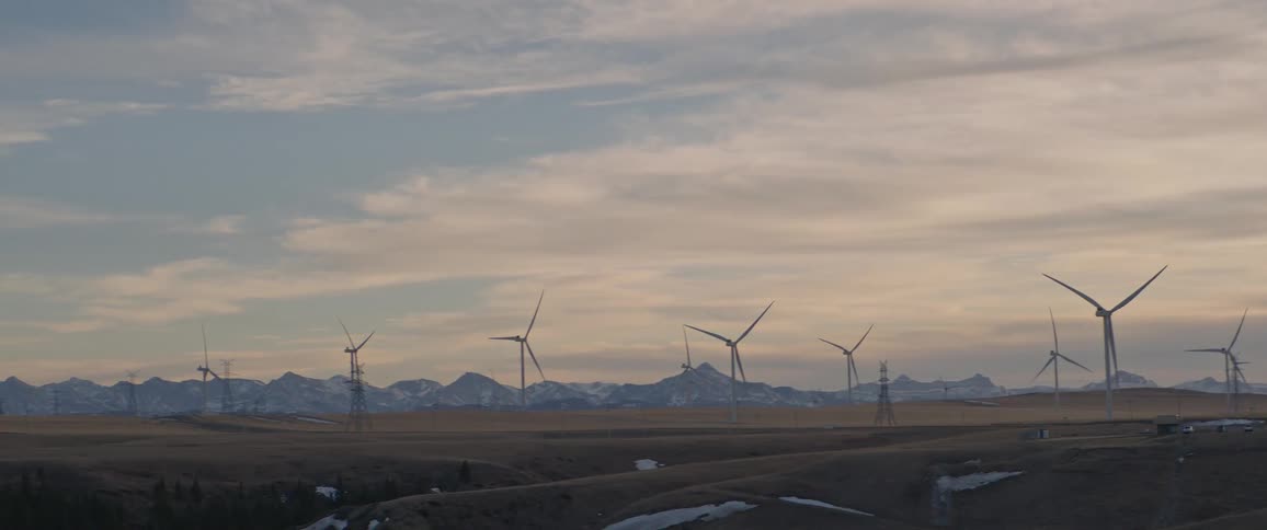 Distant wind turbines in wind farm at dusk