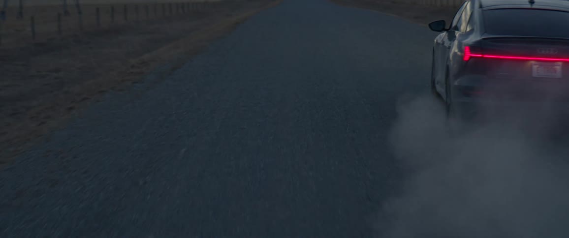 Black car driving on a rural road in the countryside at morning