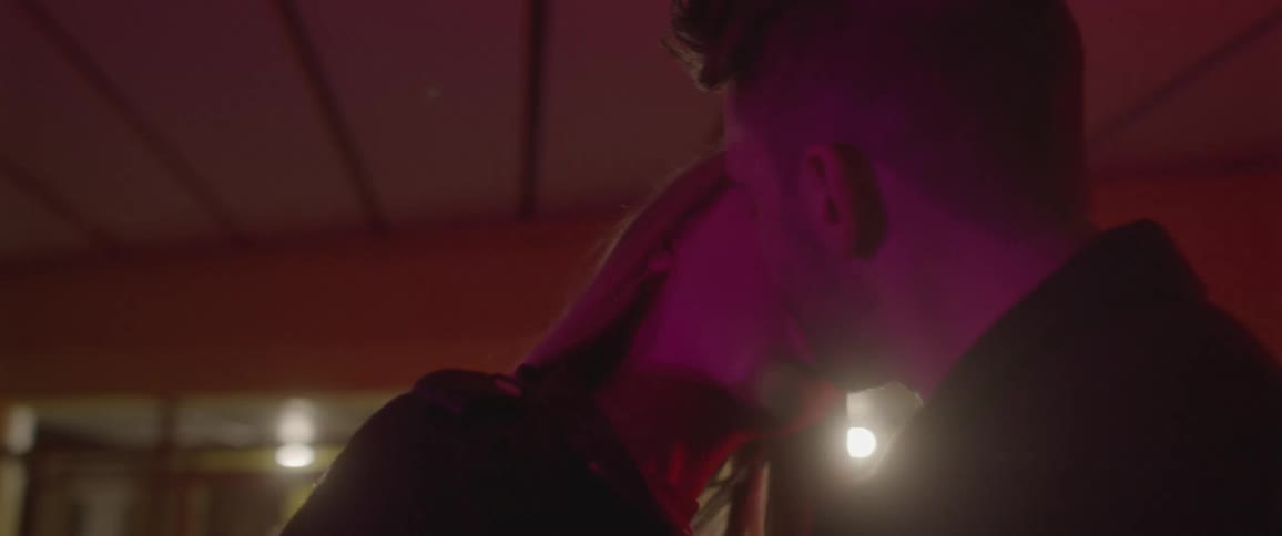 Young couple kissing in a room with red lights