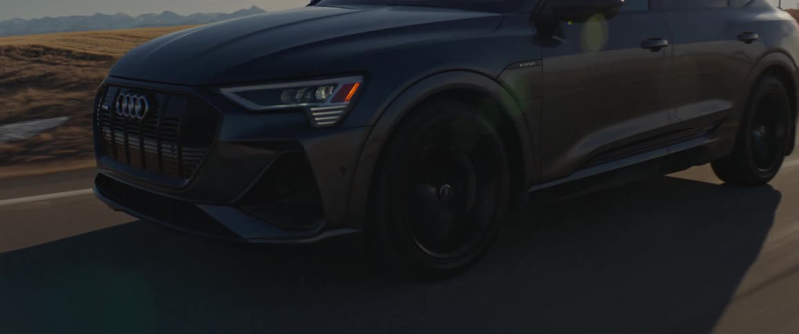 Black car driving on a road in the countryside at morning