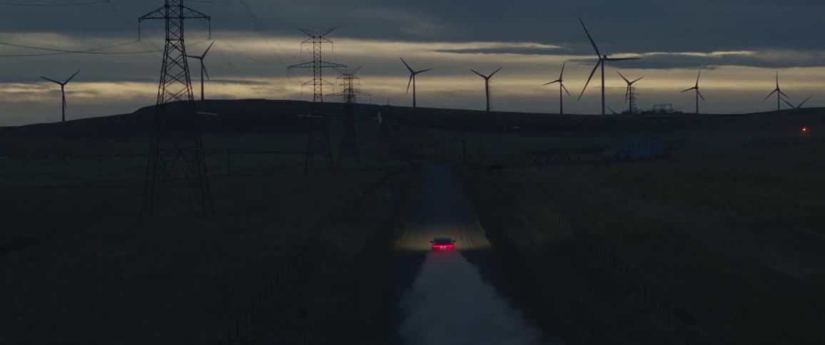 A view of a car driving down a dirt road