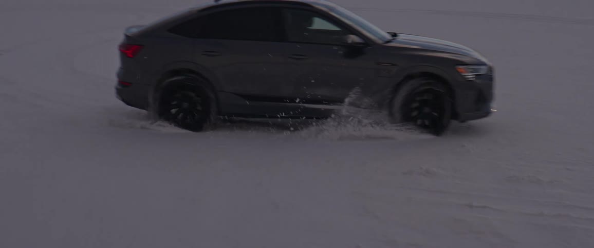 A black car is drifting on snow