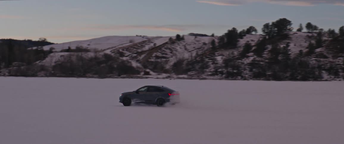 A car drives across a snow covered field