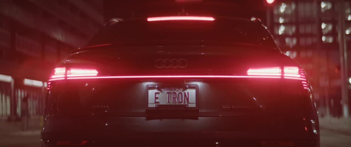Red tail lights of a car parked on the street of a city at night