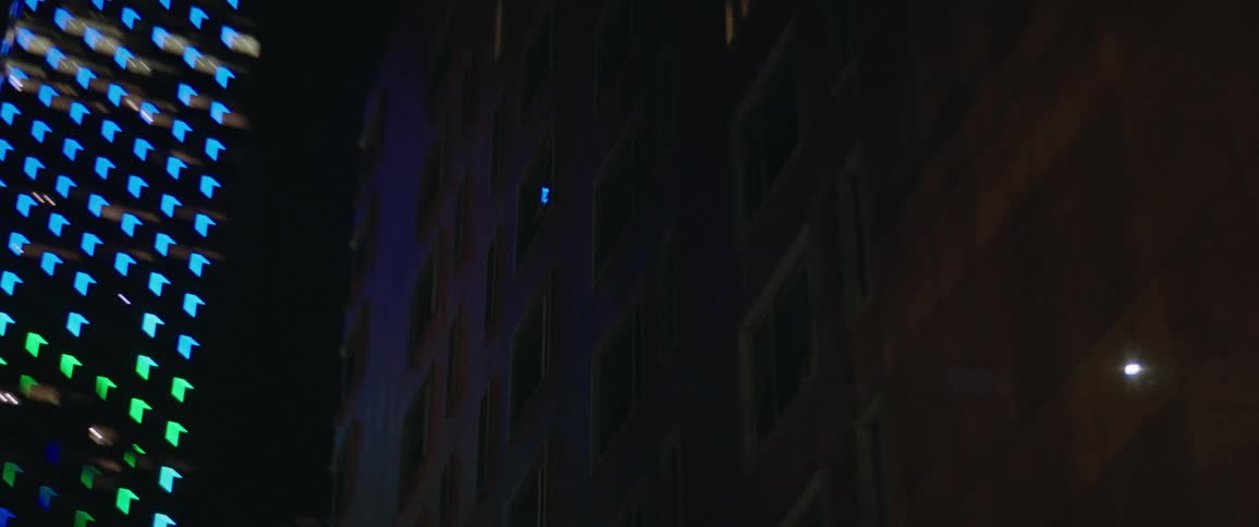 A city with buildings with windows and lights with the sky in the background