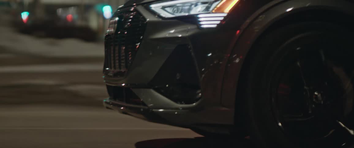 A vehicle driving on a city street with buildings in the background