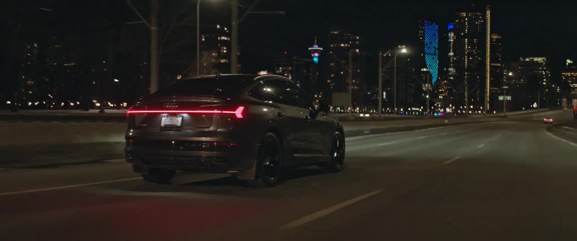 A car travels a city highway at night