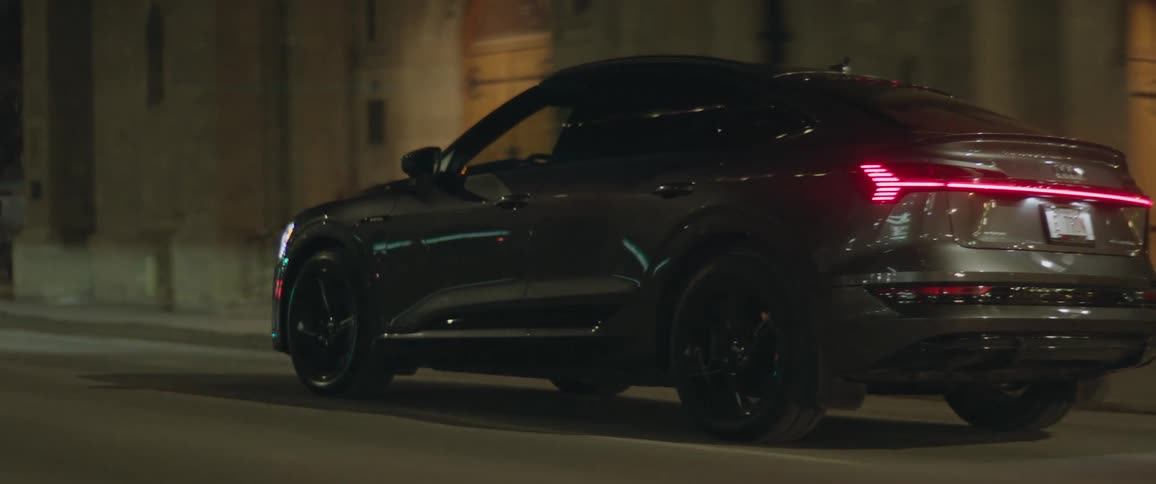 A car is driving through a downtown city at night