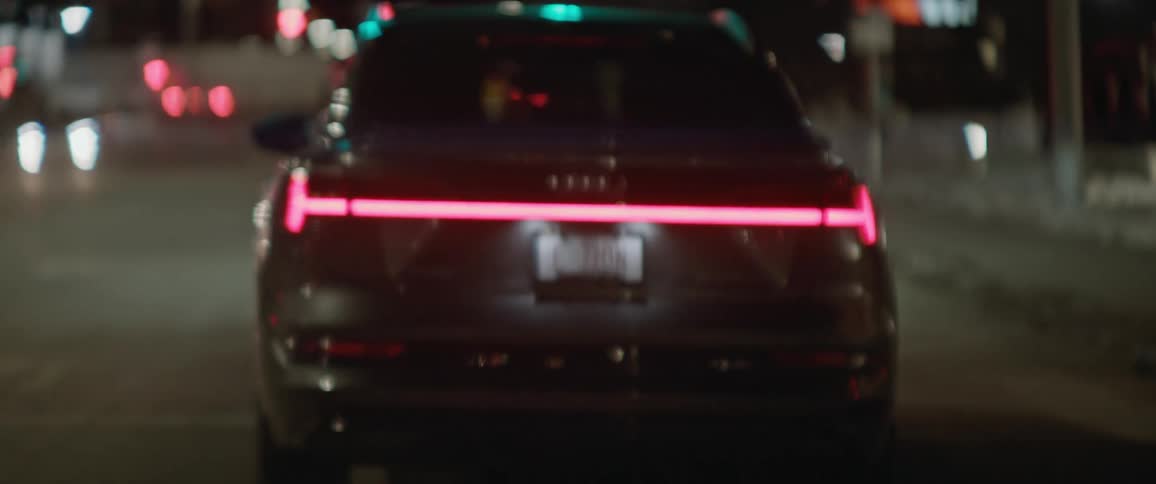 Cars drive along city streets at night