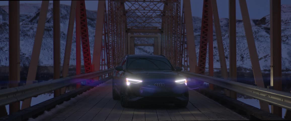 A car sits on a bridge with its headlights on