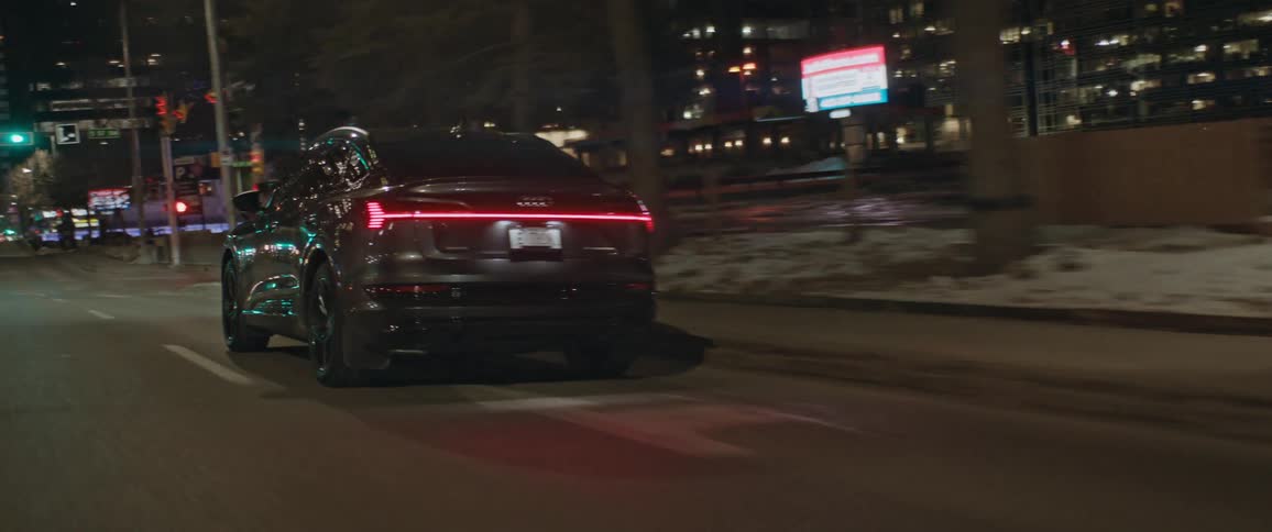 Dark grey audi car drives and indicates right on the city highway at night