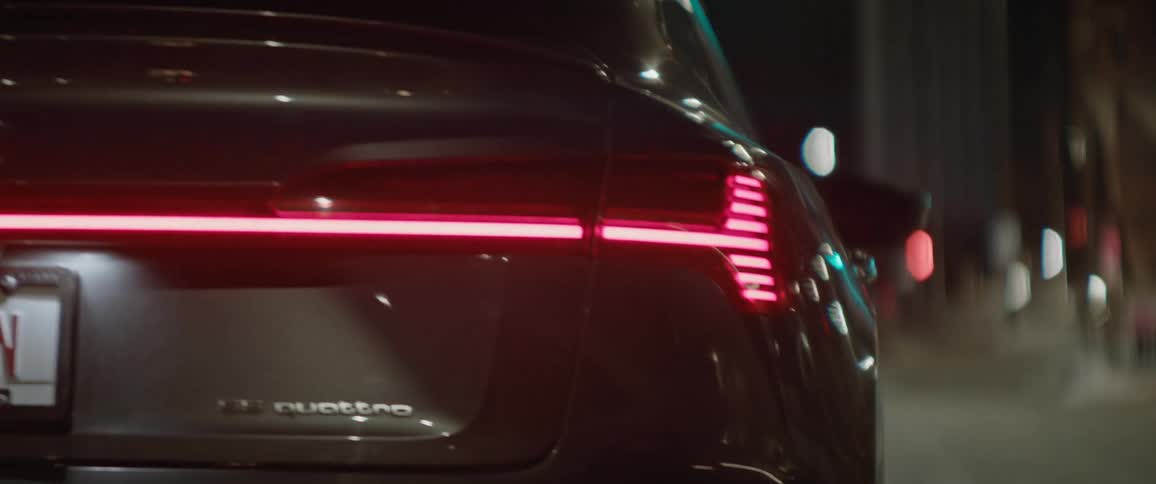 Black car driving on the street of a city at night