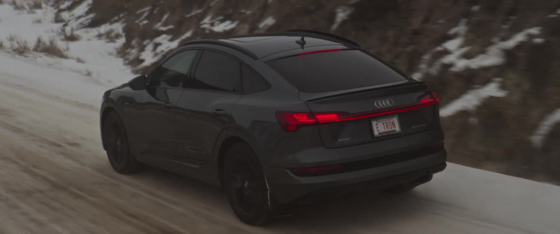 A car is driving on a road in winter