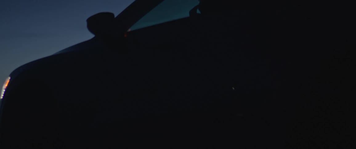 Black car driving on a rural road in the countryside at morning