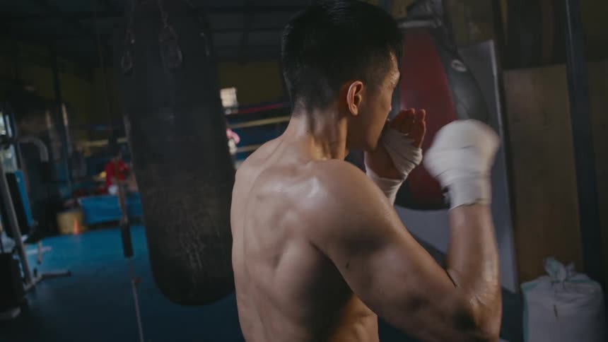 A man is shadowboxing in the gym