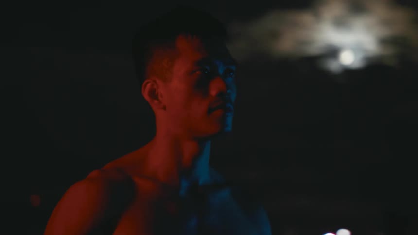 A man is standing outside at night