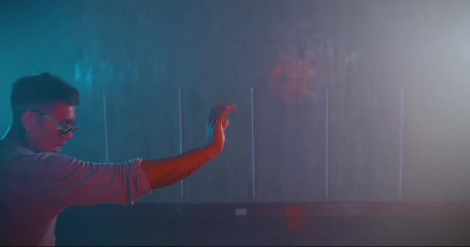 Young asian man wearing sunglasses dancing inside a room filled with smoke