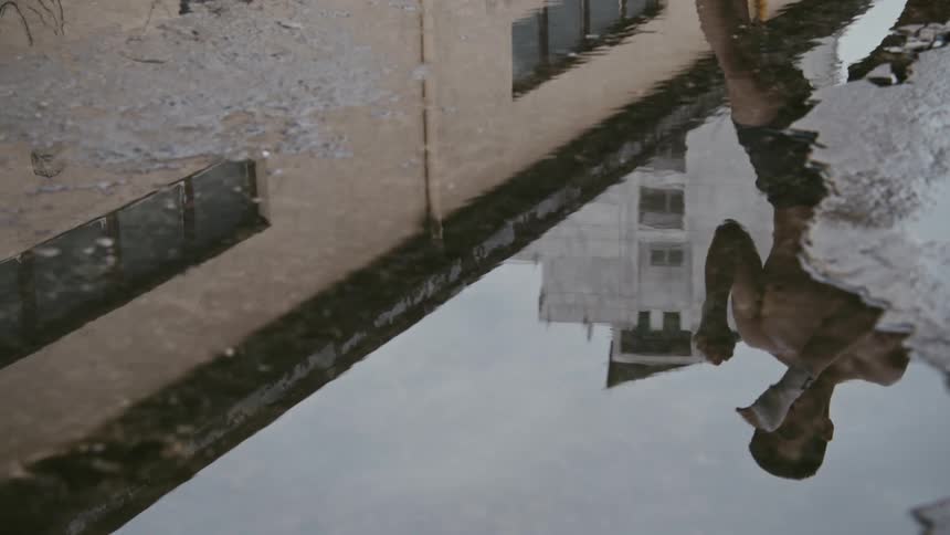 Young muscular shirtless man shadow boxing reflected on a puddle of water