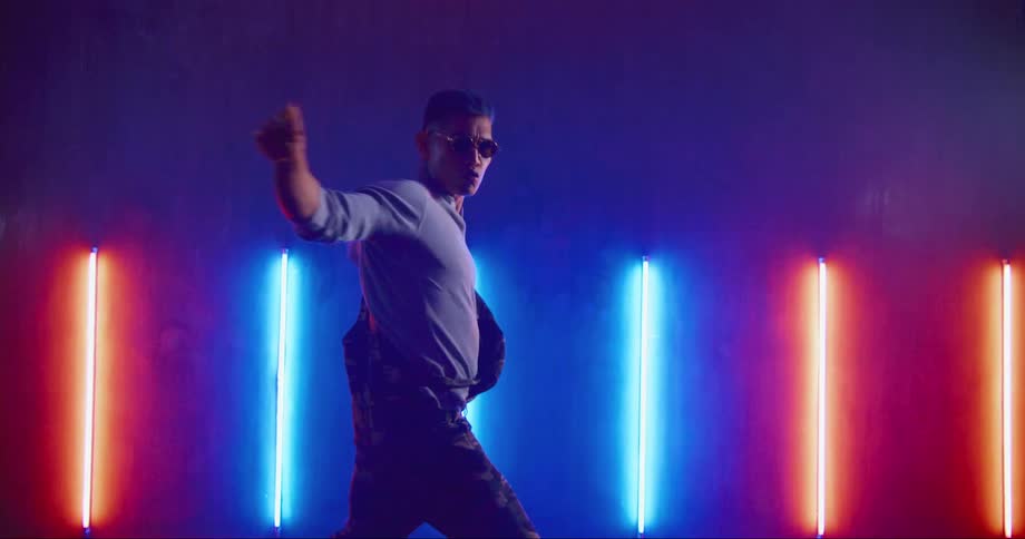Hip hop dancer rehearsing in a studio filled with neon lights