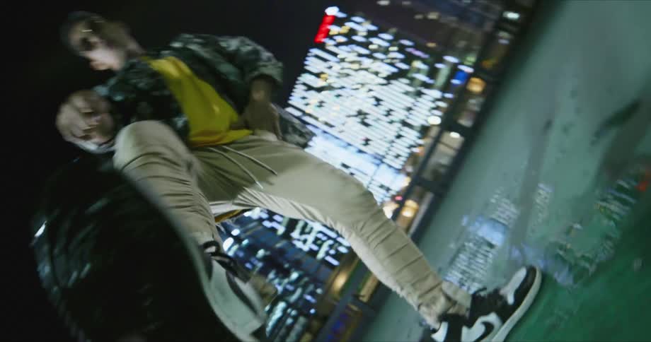 A man with sunglasses dancing with buildings in the background