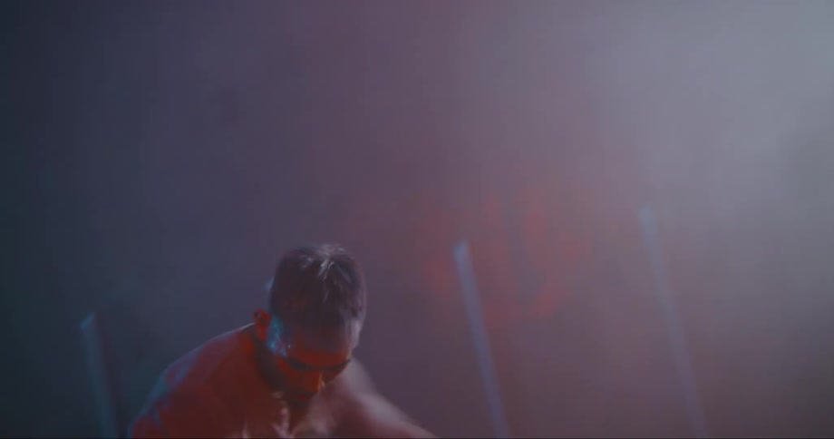 A man is dancing indoors in an empty room