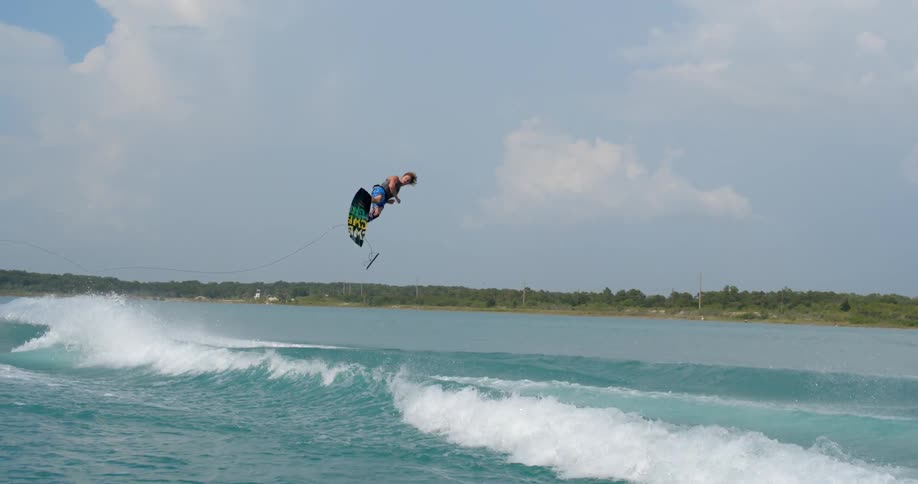 A man does a jump and multiple spins while water skiing