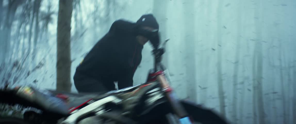 A man is doing some stunts with his motorcycle in the forests