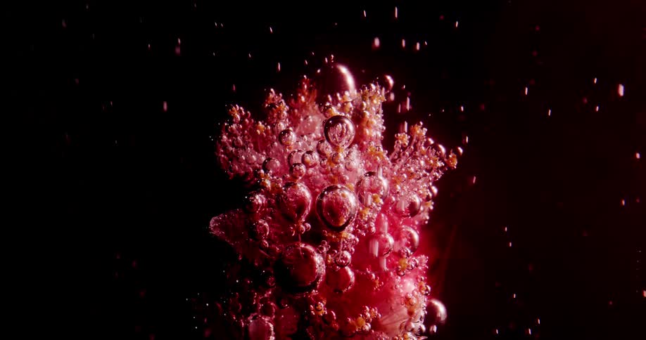 Red bubbles rise in the dark water