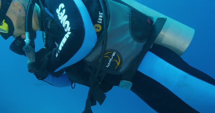 A man is scuba diving during the day