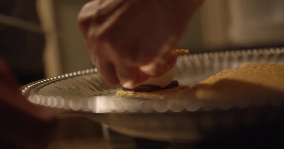 A man assembles smores on a plate
