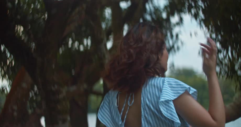 A couple laugh and dance by a lake
