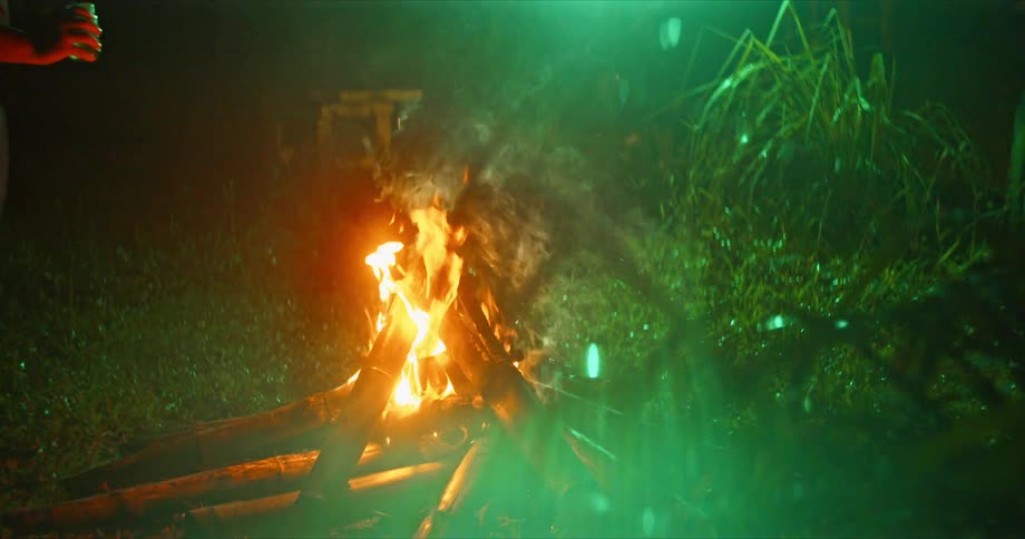 Lighter fluid is poured on the campfire