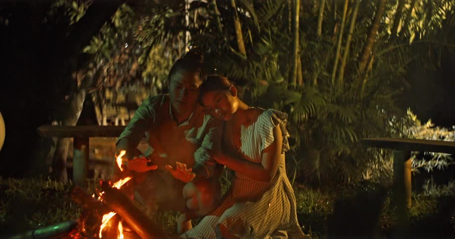 Couple sitting in front of a campfire in a park