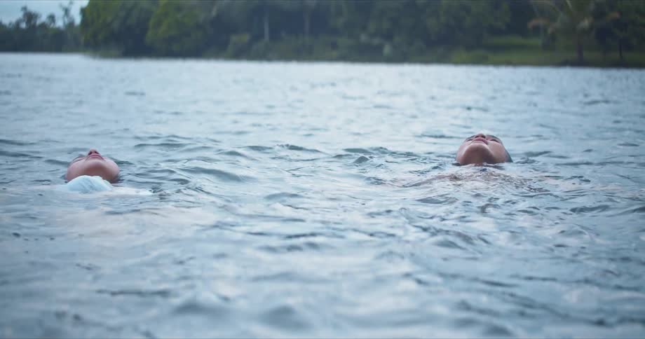 Two people are floating in a water body