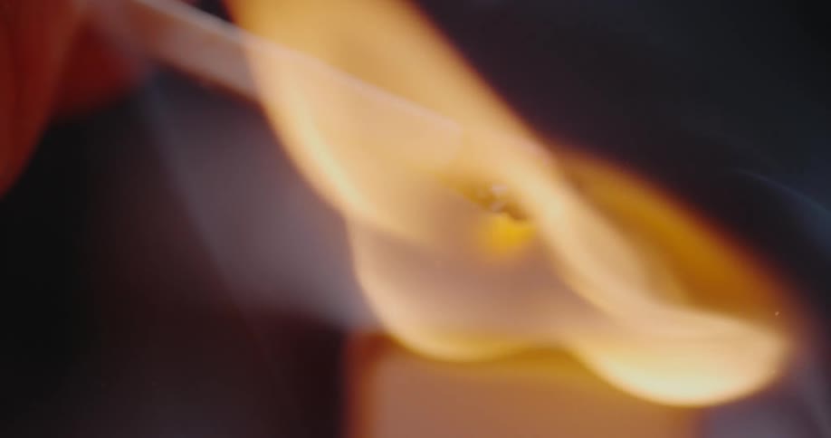 Close up of hand holding a burning matchstick