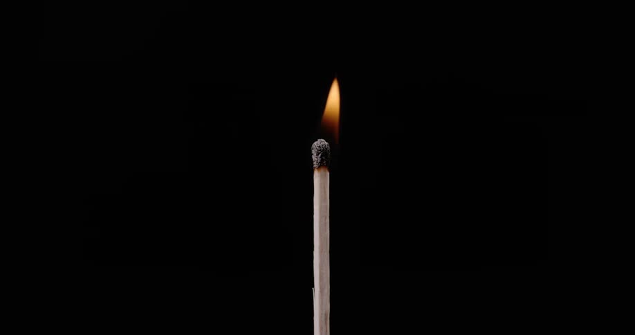 A flame rises from a match and then goes out and smoke rises