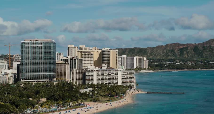 Dozens relax on a beach lined with resorts and hotels