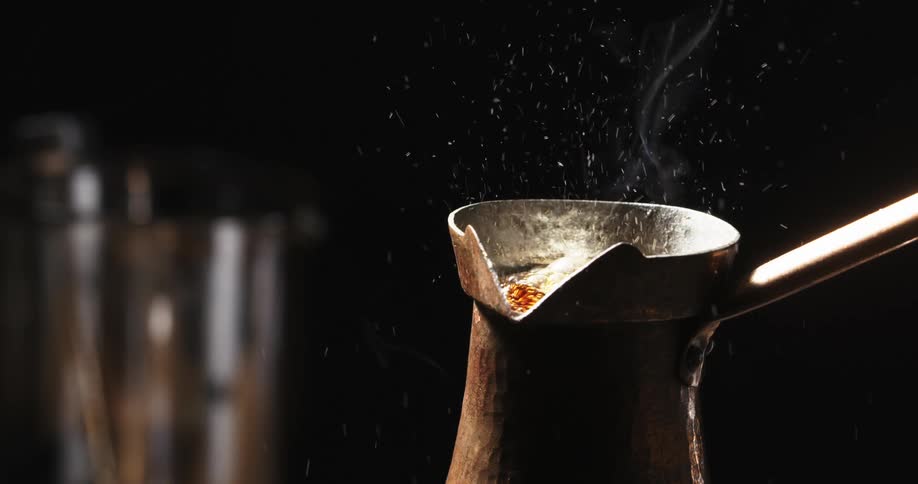 Coffee boiling inside a vintage coffee maker inside a dimly lit room