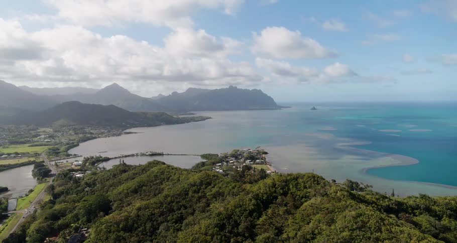 An aerial view of cars driving along the coast and the calm water