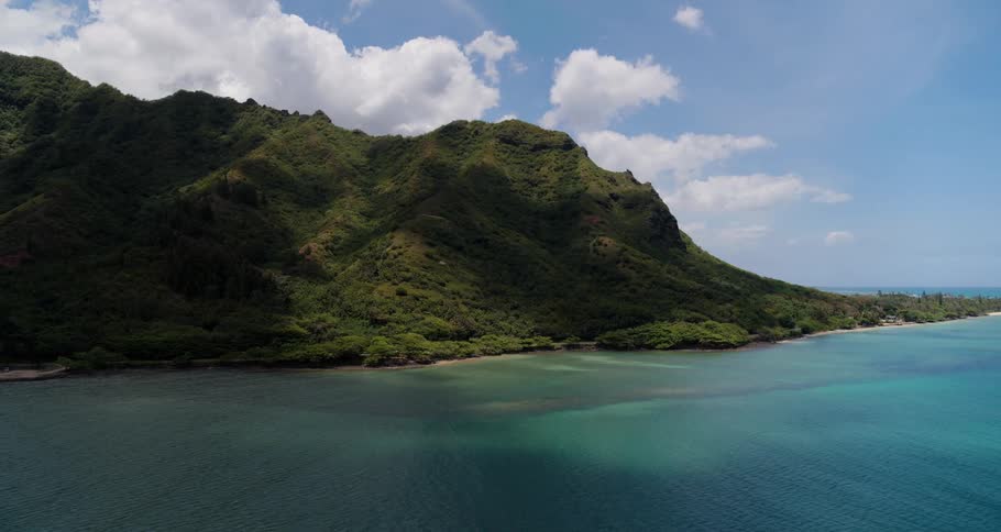 Coastal beach and promontory under a cloud filled sky