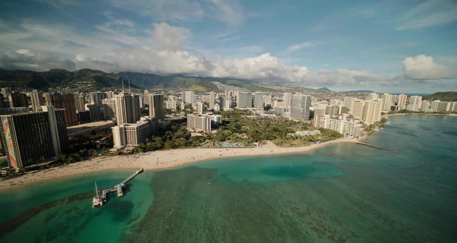 City stretches from forest covered mountains to blue green ocean