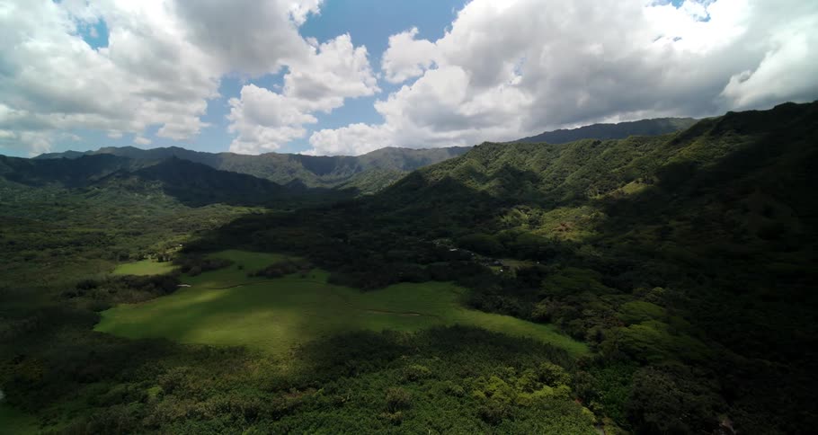 A landscape with trees and hills with the sky and clouds in the background
