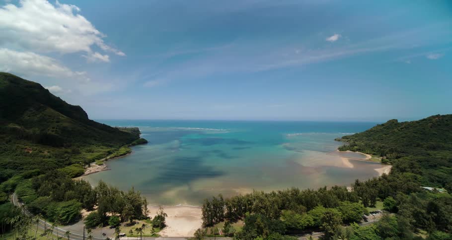 A river runs through lush countryside and washes onto the ocean