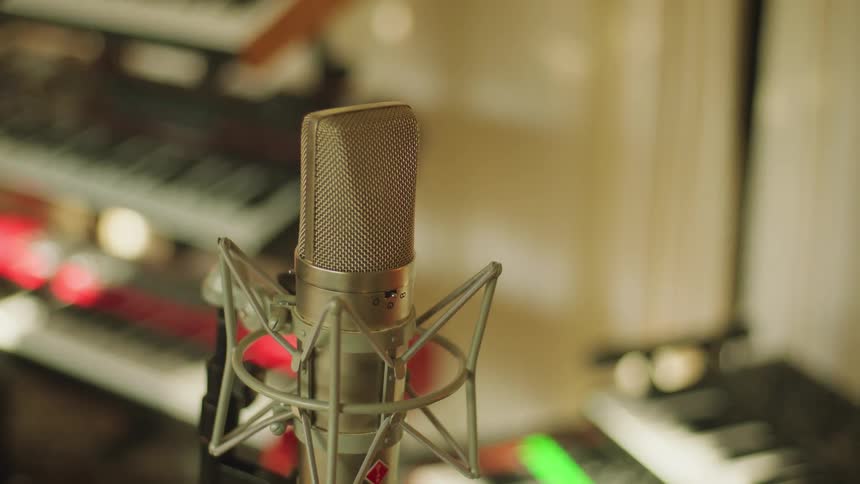 Electric pianos and a grey microphone in the studio