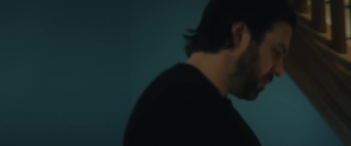 A man is pacing while talking on the phone