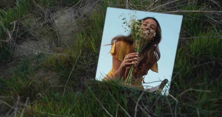 A portrait of a woman in a mirror holding flowers